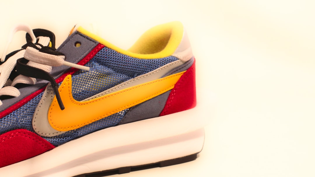 A pair of sneakers with a yellow and blue shoelace